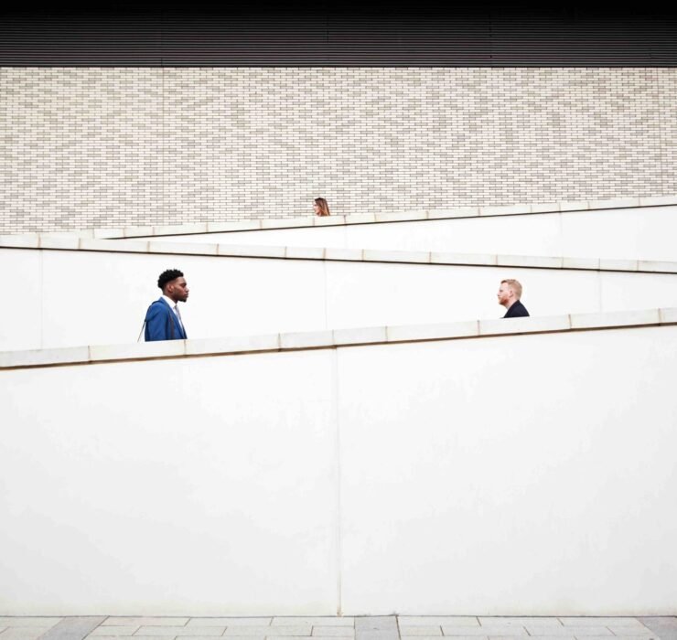 Commuters walking in opposite directions along modern ramps, illustrating the importance of using real data to understand and validate customer problems.