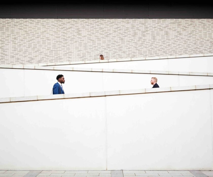 Commuters walking in opposite directions along modern ramps, illustrating the importance of using real data to understand and validate customer problems.