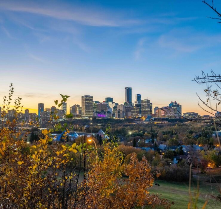 View of Calgary skyline at dusk surrounded by autumn foliage, representing a hub of innovation and thriving startups.